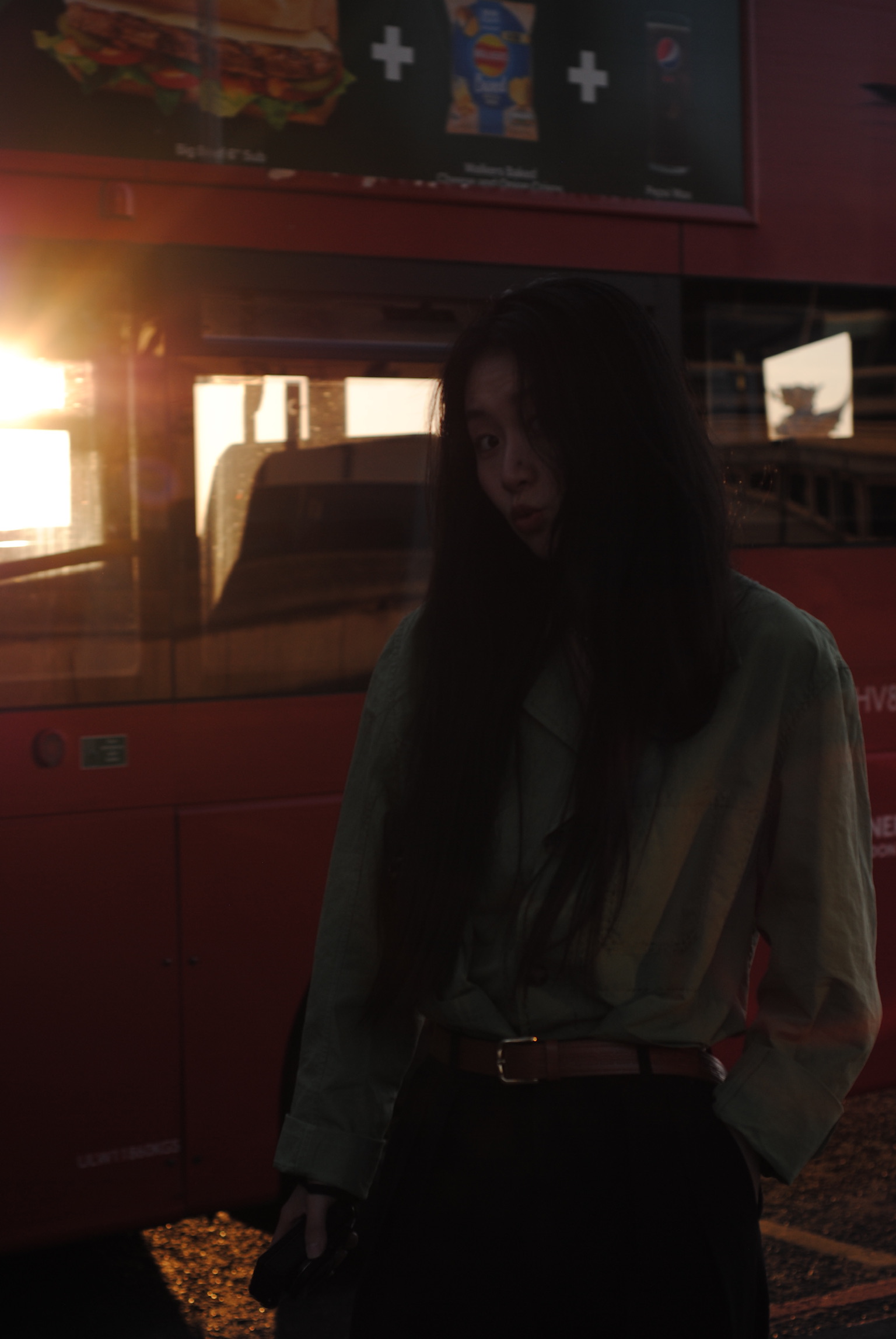 Woman with long dark hair before red food truck at dusk
