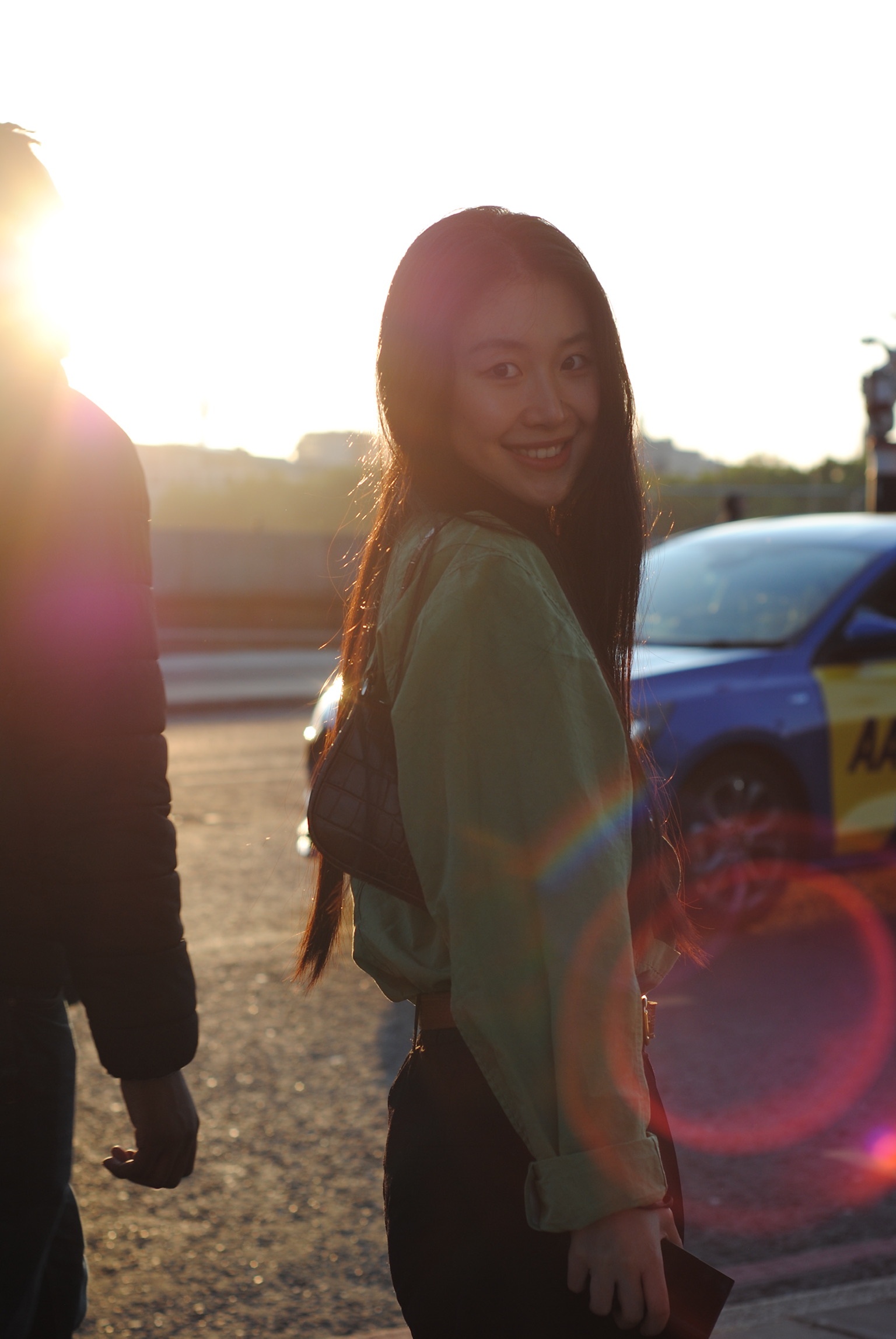 Young woman smiling over shoulder at golden hour