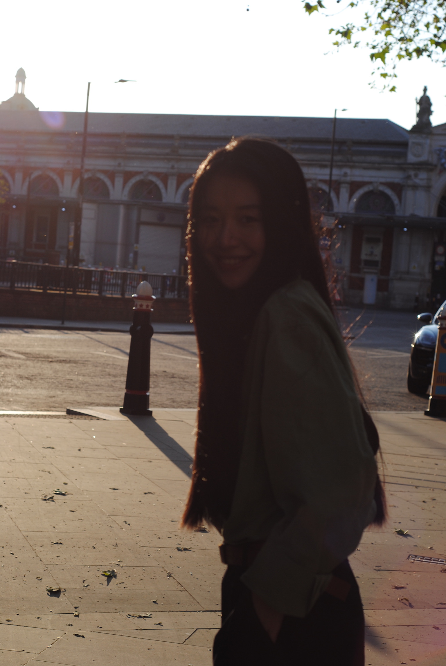 Silhouette of woman in urban square with historic arch